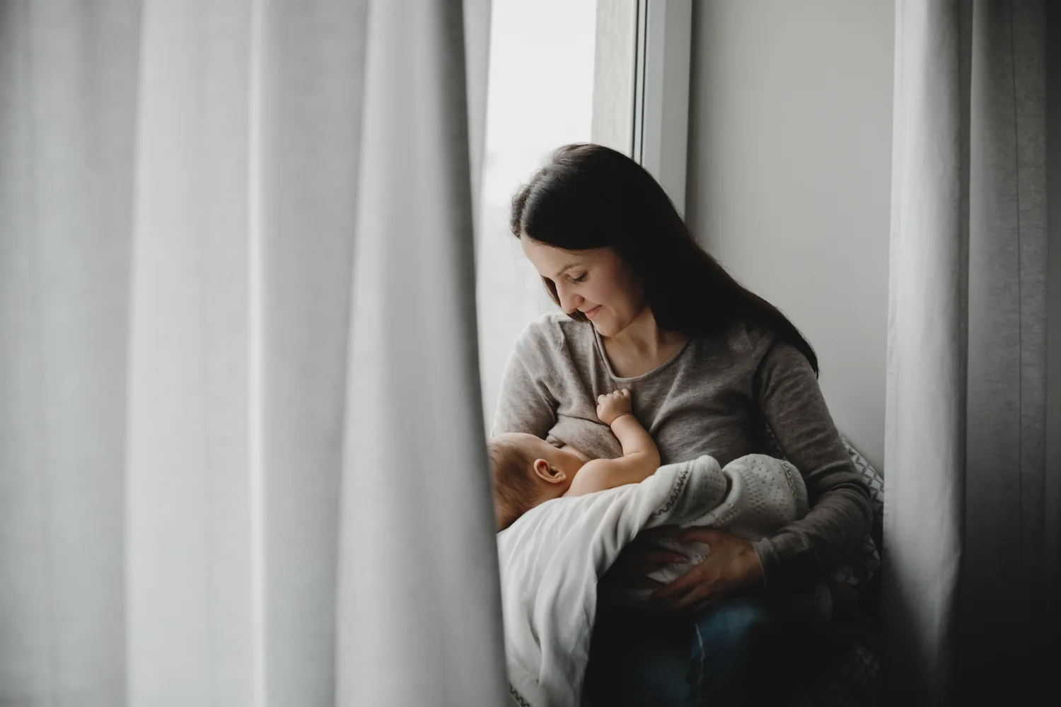 Madre recibiendo cuidados postnatales y orientación profesional con su bebé recién nacido